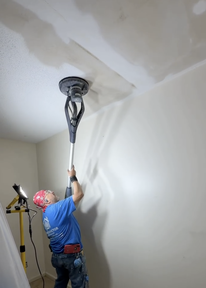 Home Doctor Construction using a long-reach ceiling sander during popcorn ceiling removal