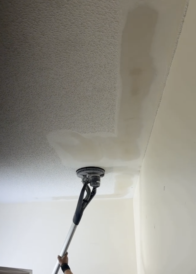 Popcorn ceiling being sanded and prepared for a smooth finish