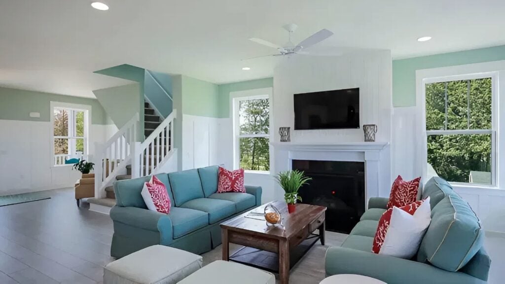 Living room with soft mint walls, crisp white trim, and cohesive interior paint by a painter in Summerfield, NC